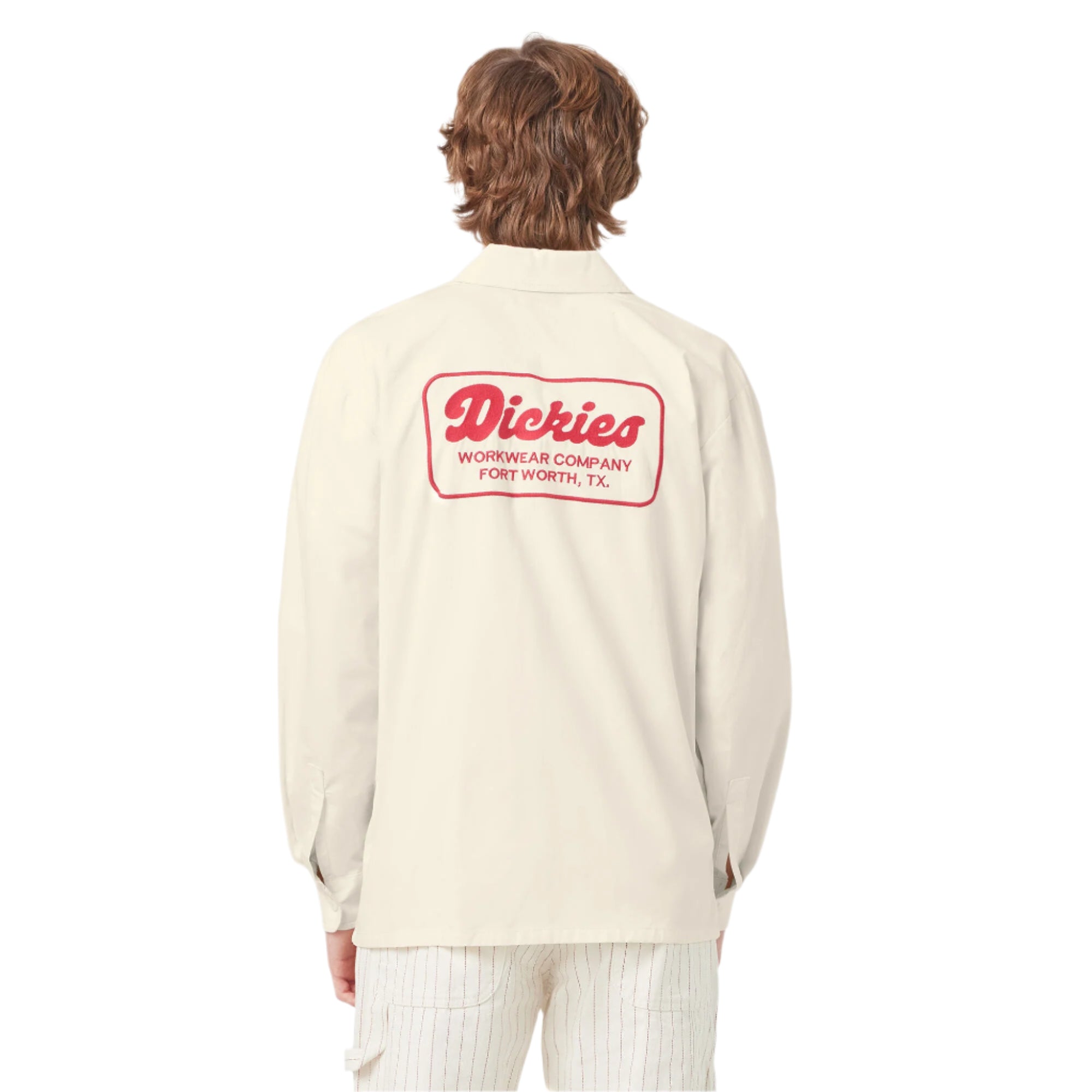 Person wearing a cream-colored shirt with a red logo on the back, standing against a white background